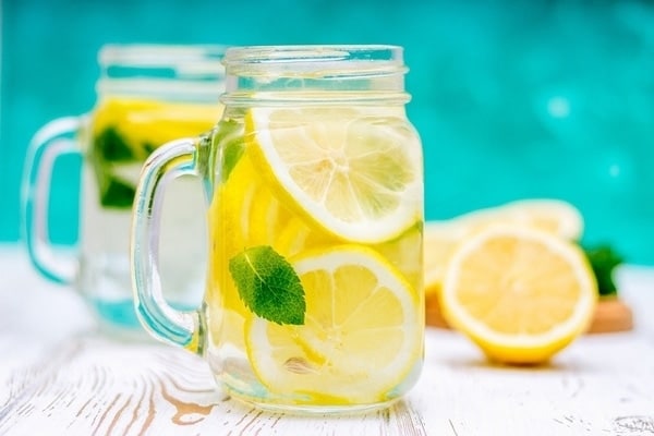 Citronová voda s plátky citronu a mátou ve skleněném půllitru