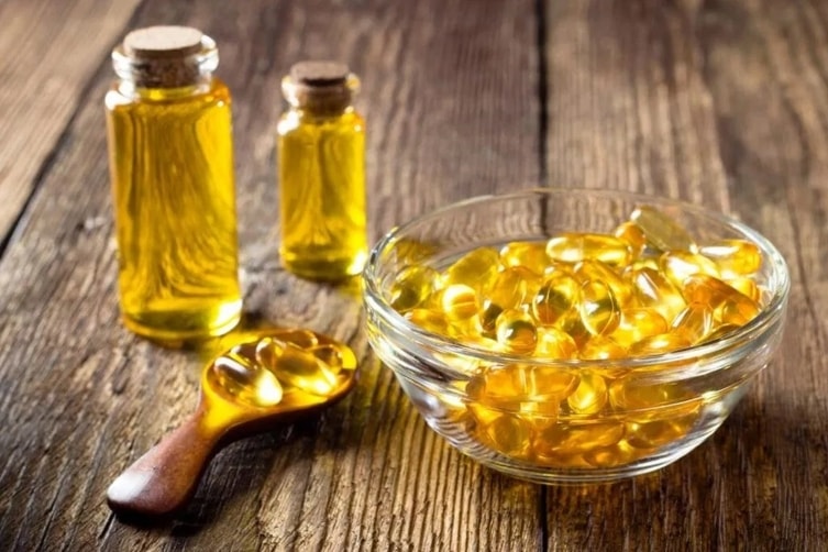 Suplementace omega-3 mastných kyselin ve formě kapslí ve skleněné misce, a oleje v ampulkách