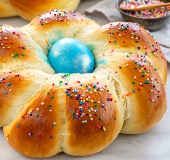 Italský velikonoční mazanec s modrým vajíčkem uprostřed a s barevnou posypkou